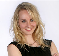 Headshot of author A.C. Anderson (sci-fi pen name for Alexia Chantel), blonde woman with blue eyes wearing a black dress.