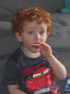 Red haired toddler eating a wafer snack