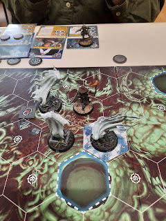 A photo of an Underworlds game in progress. Hexbane is surrounded by three banshees.