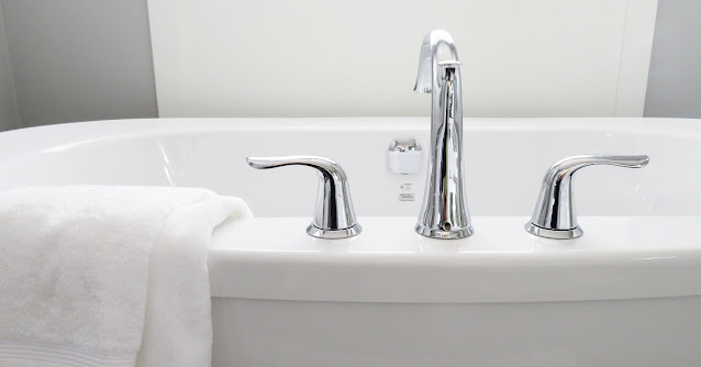 Close up of side-mounted faucet on a soaking bathtub.