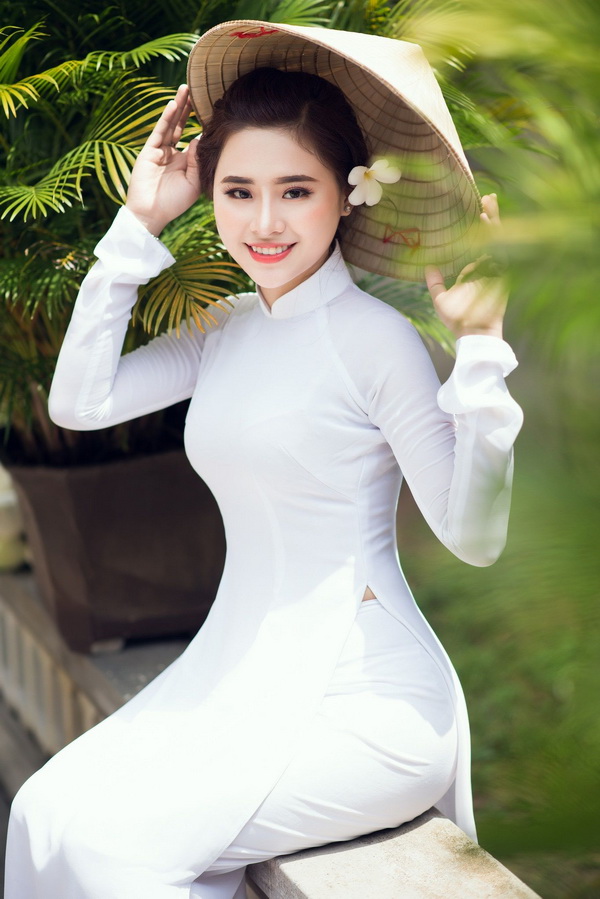 Thiếu nữ ngồi áo dài trắng, nón lá