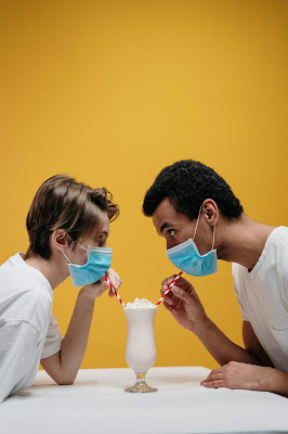 couple drinking juice wearing a surgical mask