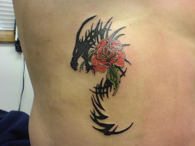  white in color but then the red. Black tribal dragon and red rose tattoo