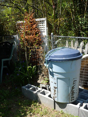 garbage can compost tumbler on blocks