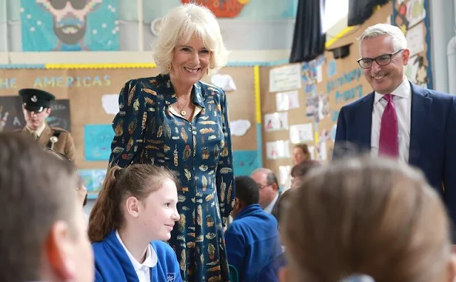 Queen Camilla wore a v-neck colourful feather printed midi dress. She also donned a pair of classic black pumps