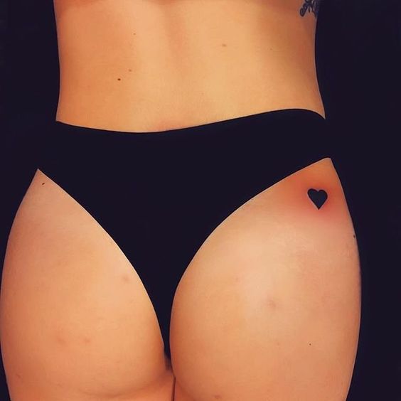 Small minimalist heart tattoo on the buttock