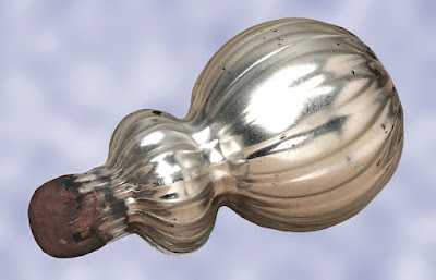 A silver curvy bottle with a stopper