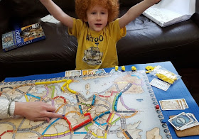 Boy cheering after winning a board game Ticket To Ride