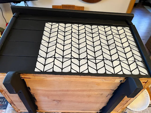 Photo of a cable knit pattern stenciled onto a storage chest.