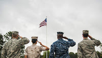 Image via Wikimedia Commons: Service members salute the American flag during a retreat ceremony Oct. 2, 2014, at Little Rock Air Force Base, Ark. The four military members represented each branch of the U.S. military and assembled to show solidarity. (Credit: U.S. Air Force photo by Airman 1st Class Harry Brexel/Released) Click to Enlarge.