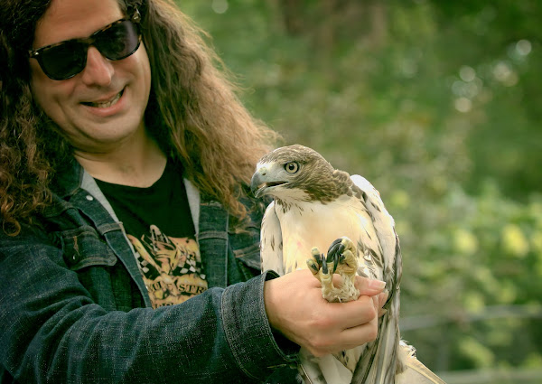 Ranger Rob holds up a fledgling red-tailed hawk.