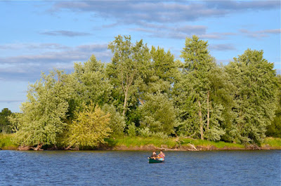 Meryl and Carlos paddling in front of the silver maples