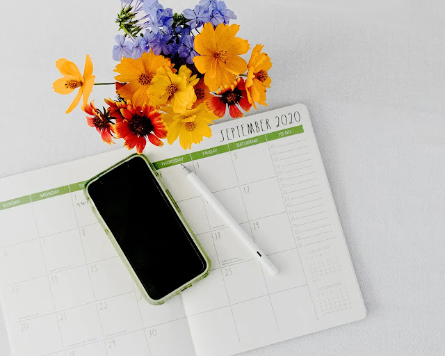A phone with a flower and notebook