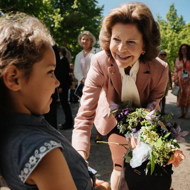 The King and Queen visited the House of Emigrants in Vaxjo. Queen Silvia wore a pink blazer and black skirt