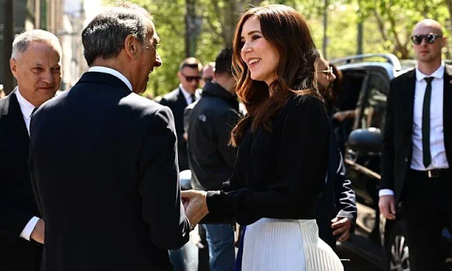 Crown Princess Mary wore a pleated chiffon midi skirt by Designers Remix, and a black v-neck silk blouse by Julie Fagerholt