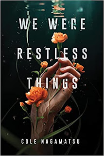 A pale hand reaching up out of the water towards the surface, orange flowers rest on the palm and a green vine twines around the wrist