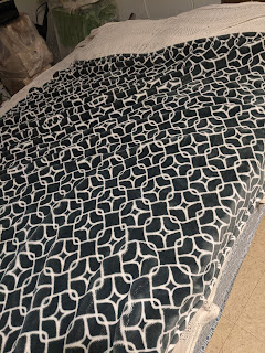 Bed with diamond print blanket covering it