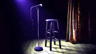 comedy stage with a mic and stool.
