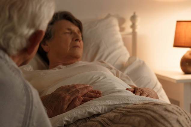 man holding wife's hand in hospice