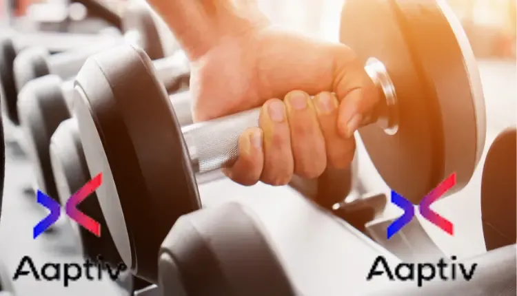 A picture of a hand in the gym holding exercise equipment with Aaptiv written on it