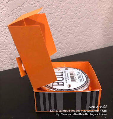 side view of the opened orange box decorated with black and gray striped paper around the side and an image of costumed trick-or-treaters underneath the moon and some bats; Halloween, treat holder, Scary Cut, 3D, box