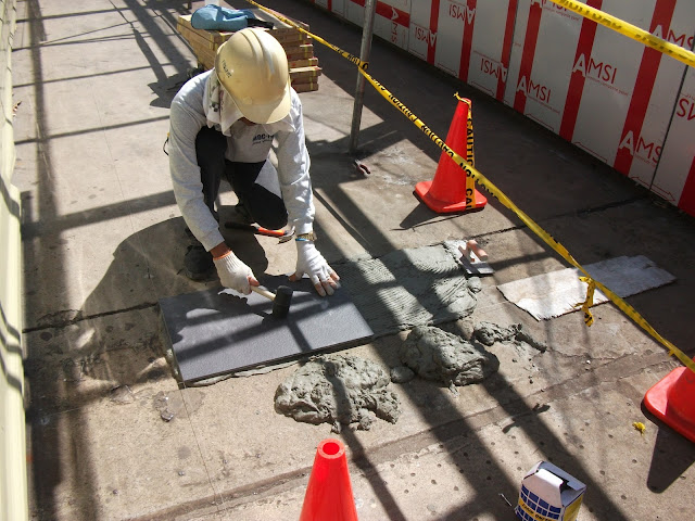 Tilesetter mason fixing a floor tile