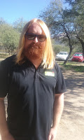 A man with glasses and red hair and a red beard wearing a black shirt - Elliott from Shipping.