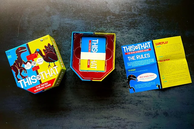 An open box of the this or that game showing the contents which is cards and instructions