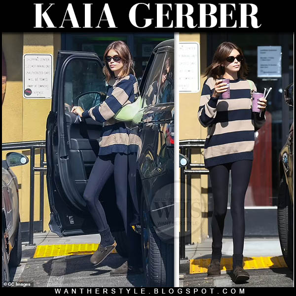 Kaia Gerber in striped sweater, black leggings with green bag