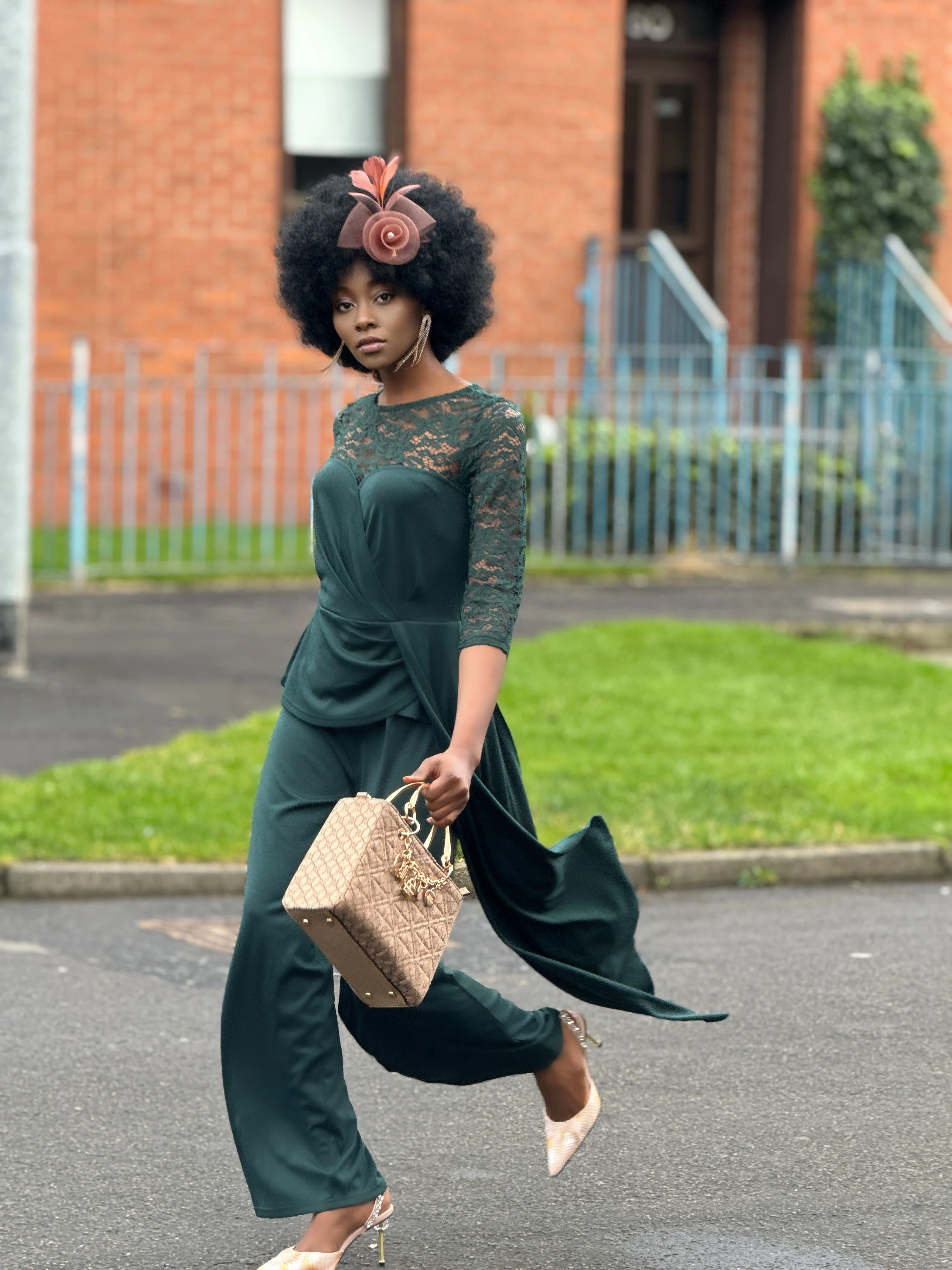 Fashion model posing in green jumpsuit with lace accents, styled for a chic daytime look.