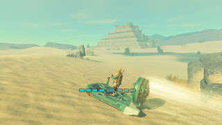 driving through the desert on a slide with a fan, the Lightning Temple in the background
