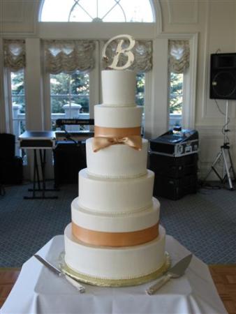 Picture of 6 Tier Stacked Buttercream Wedding Cake With Gold Ribbon