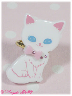 A ring with a white cat with blue eyes and a bow at her neck.