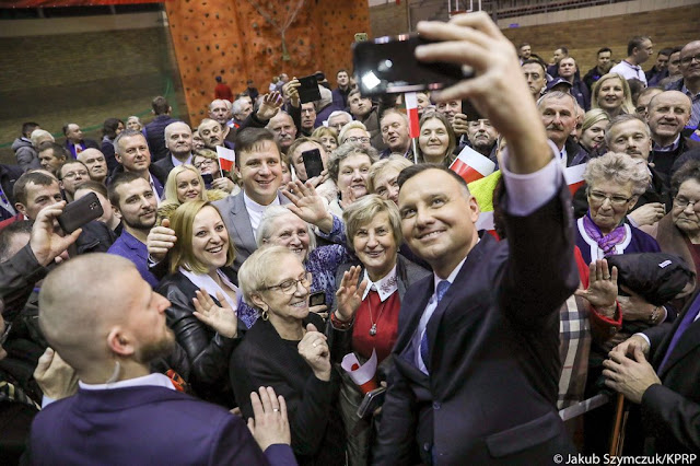 Widok Andrzej Dudy podczas robienia sobie selfie z mieszkańcami Kolna