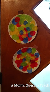 Christmas Crafts - finished paper plate Christmas ball ornaments hanging on the door