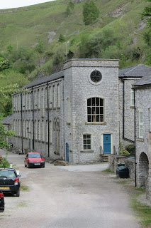 A stone building with several cars parked outside.