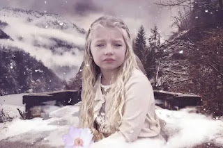 An image of a cute child girl sitting on the snow- sad girl dp
