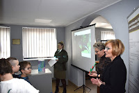 Zdjęcie przedstawia panie: Karolinę Piasecką, Anetę Kasprzykowską i Alicję Olejnik stojące w czytelni Biblioteki przed grupą dzieci.