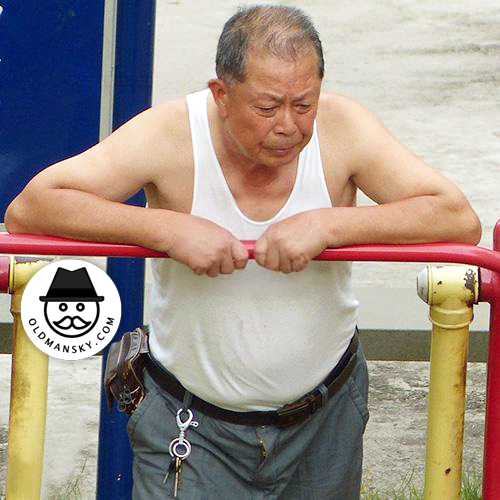 Old daddy wore white vest undershirt and gray pants was doing exercise in the park