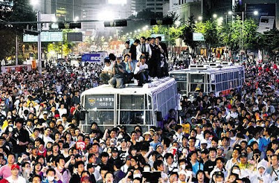 Protesters climb on top of police buses