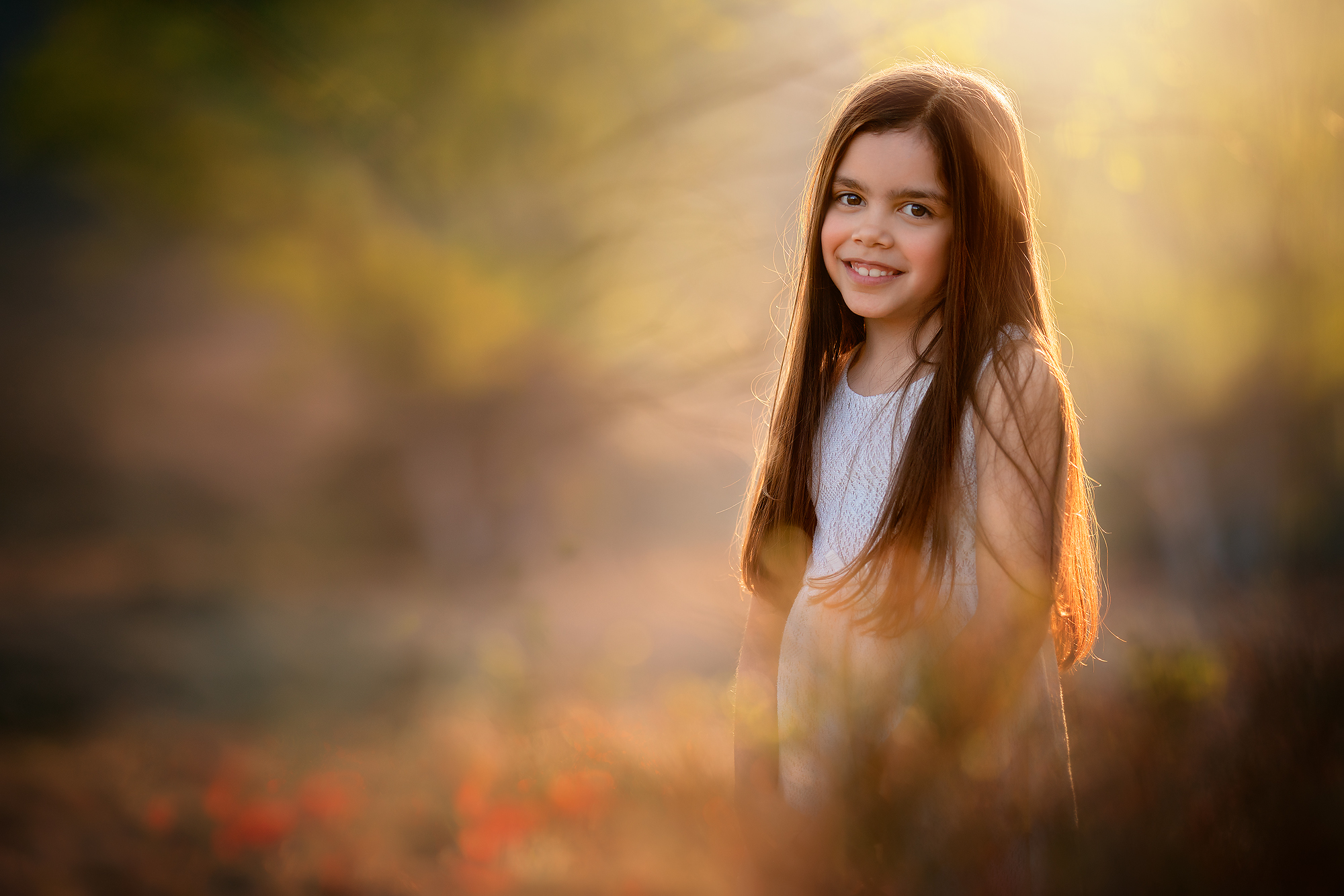 Fine art kinderportret van een meisje in een witte jurk tussen de bloemen door natuurlijk licht fotograaf Willie Kers uit Apeldoorn