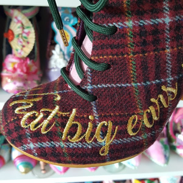 close up of side toe of ankle boot with gold embroidered text