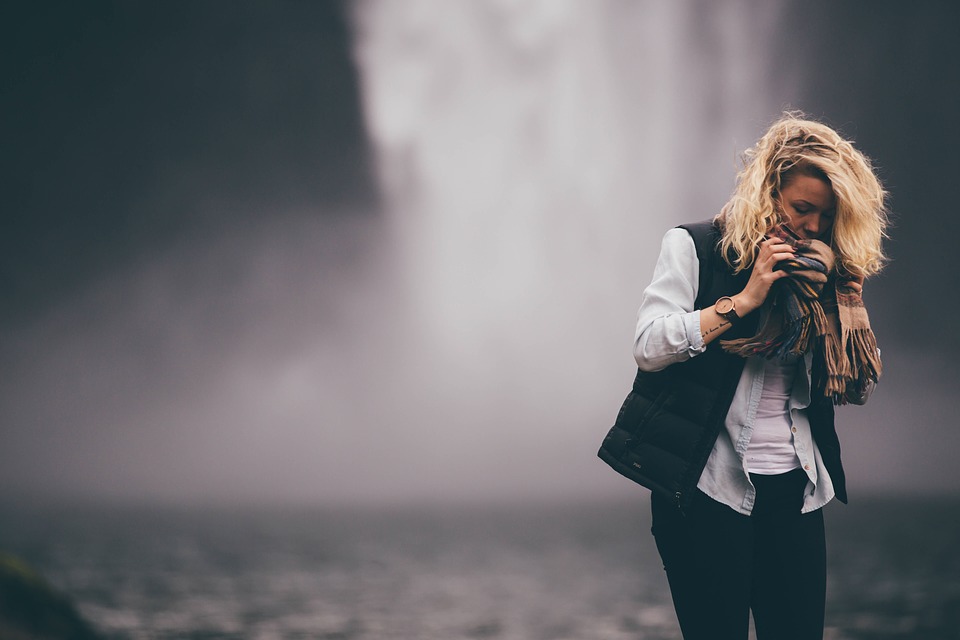 Elegant woman in front of a waterfall