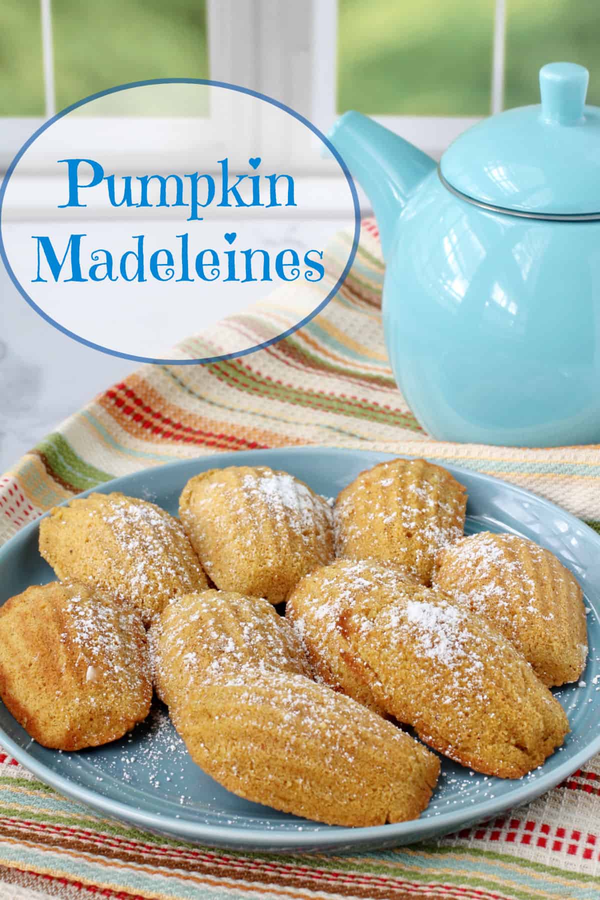 Pumpkin Madeleines on a blue plate and sprinkled with powdered sugar.