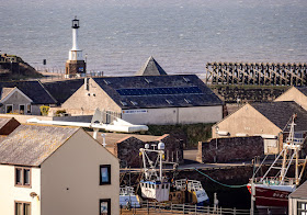 Photo of view across the rooftops to Maryport Lighthouse and the Solway Firth