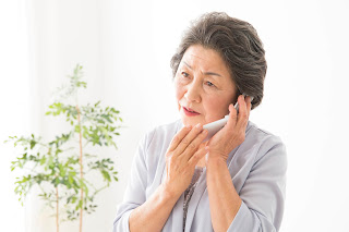 老人性難聴が原因で電話の聞き取りが悪く、困っている女性の写真