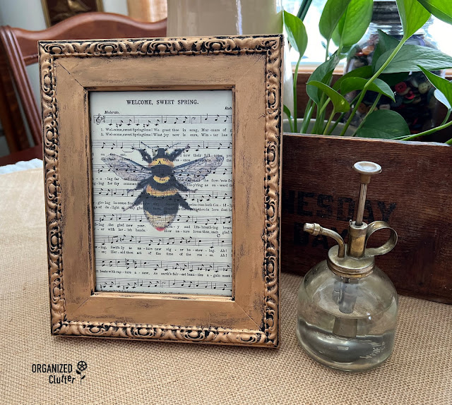 Photo of an upcycled frame with vintage songbook page butterfly graphic.