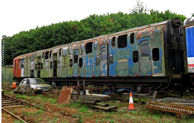 A neglected and vandalised solitary coach of the experimental double-decker electric train stands on sidings at the Northampton & Lamport Railway