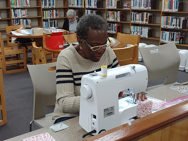 A patron is carefully using a sewing machine at the Springville Road Regional Branch Library