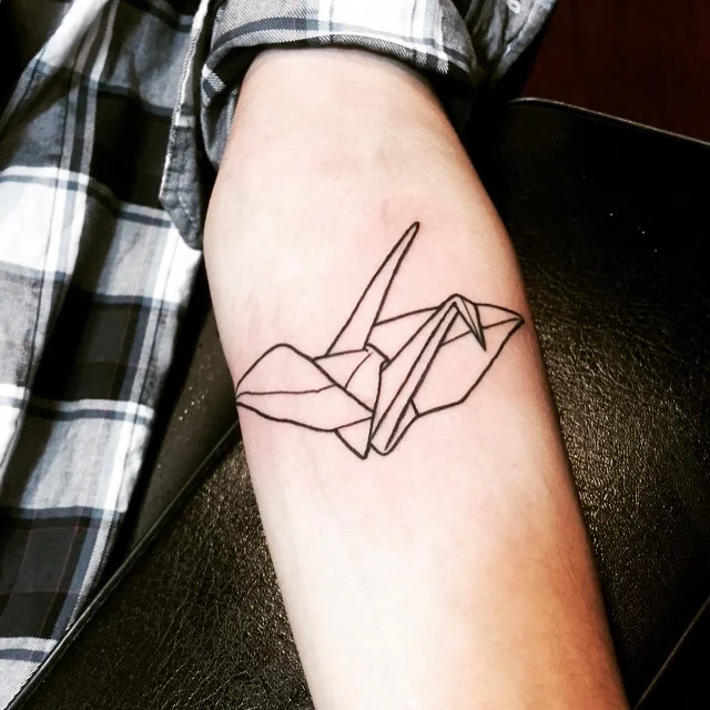 fotografia del tatuaje de una figura origami